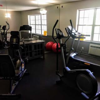 A well-equipped fitness room featuring various exercise machines and free weights.