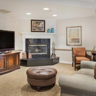 A cozy living room with a fireplace, television, and comfortable seating.