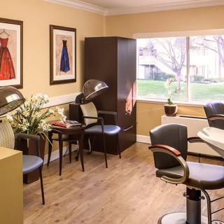 A well-lit salon interior with stylish chairs and hair styling equipment.