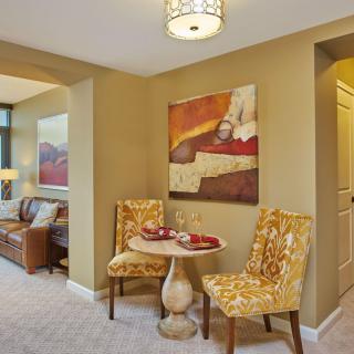 A cozy living room and dining area featuring elegant furniture and vibrant artwork.
