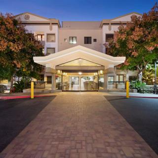 The entrance of a well-lit hotel building at night.
