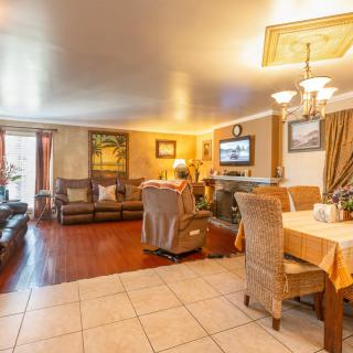 A cozy living and dining space with comfortable seating, warm lighting, and a television.