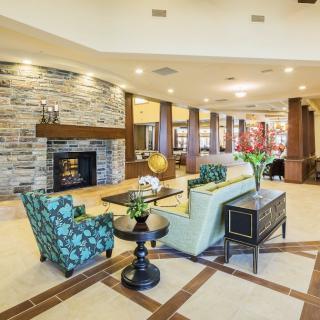 A modern and elegant lobby featuring a cozy seating area with a fireplace.