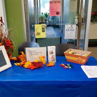 A welcoming information table decorated for autumn in a community space.