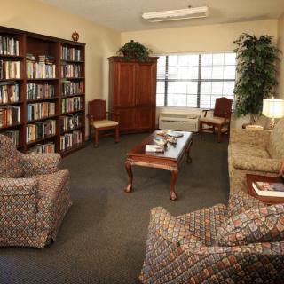 A cozy library reading room with comfortable seating and bookshelves.