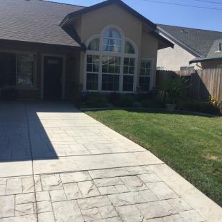 A suburban house with a driveway and well-maintained lawn.