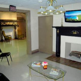 A cozy lobby area with a fireplace, television, and seating.