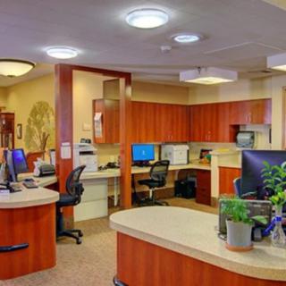 Modern office reception area with desks and computers.