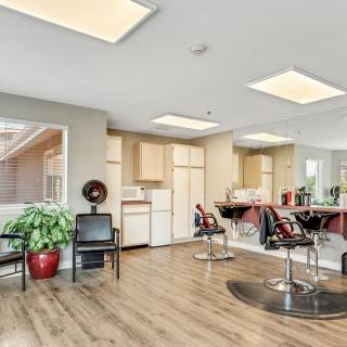 A modern hair salon interior with styling chairs, large mirrors, and bright lighting.