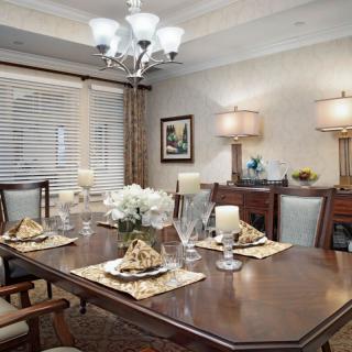 A beautifully decorated dining room with an elegant table setting and chandelier.
