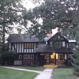 A charming Tudor-style house surrounded by trees during twilight.