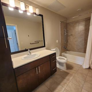 A modern bathroom featuring a stylish vanity with a large mirror and well-lit fixtures.