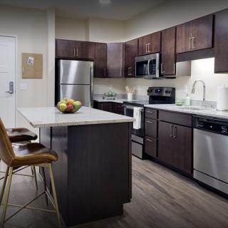 A modern kitchen with stainless steel appliances and a central island.