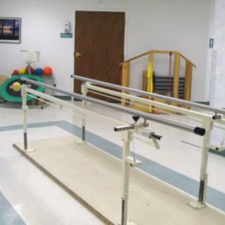A rehabilitation room equipped with parallel bars for physical therapy exercises.