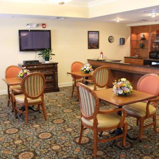 A cozy dining area with elegant tables and chairs, featuring floral centerpieces.
