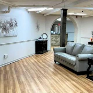 A modern living room with a couch, wood flooring, and stylish decor.