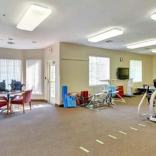 A well-equipped physical therapy room with exercise machines and seating areas.