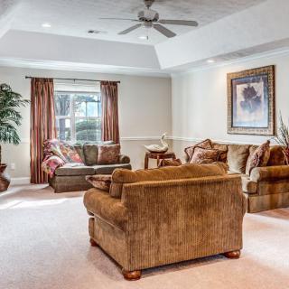 A cozy living room with comfortable sofas, a coffee table, and warm decor.