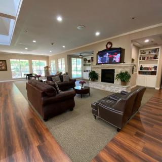A spacious and well-lit living room with comfortable seating and a fireplace.