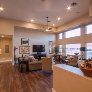 A modern and spacious living room with cozy furniture and warm lighting.