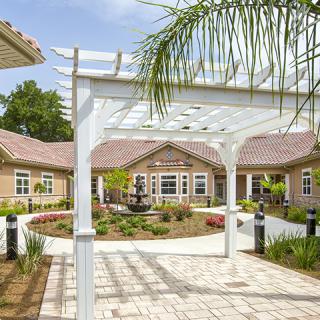 A beautifully landscaped courtyard with a white pergola and garden pathways.