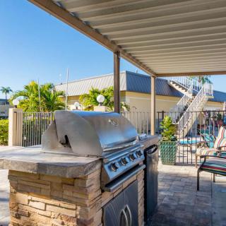 A sunny outdoor patio with a barbecue grill and seating area.