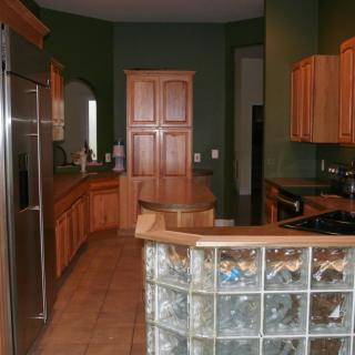 A modern kitchen with wood cabinets and glass block accents.
