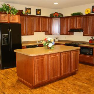 A modern kitchen featuring wooden cabinets, a central island, and appliances.