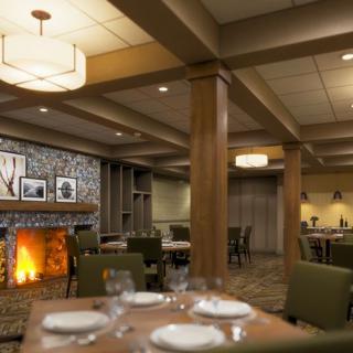 A cozy restaurant dining room with a fireplace and neatly arranged tables.
