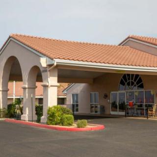 A hotel entrance with arched design and well-maintained landscaping.