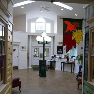 A well-lit lobby area featuring a unique lamp post and vibrant leaf artwork on the wall.