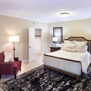 A cozy bedroom with a large bed, decorative pillows, and elegant furniture.
