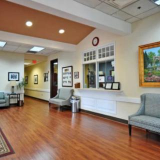 A spacious and well-lit waiting room with comfortable seating and artwork on the walls.