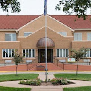 A modern brick building featuring an elegant entrance and well-maintained landscaping.