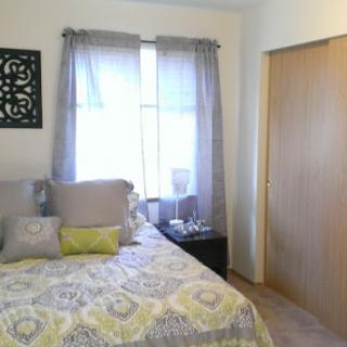 A cozy and well-decorated bedroom featuring a comfortable bed and elegant curtains.