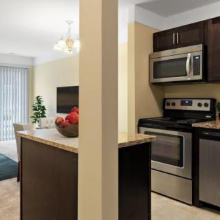 A modern kitchen with stainless steel appliances and an adjacent dining area in an open layout design.