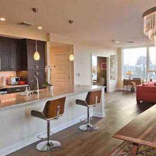 A modern open-concept living space featuring a stylish kitchen and comfortable seating area.