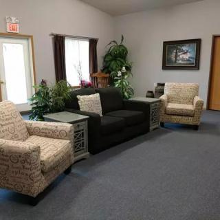 A cozy living room setup with a sofa, armchairs, and decorative plants.