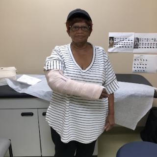 An individual with a cast on their arm in a medical setting.