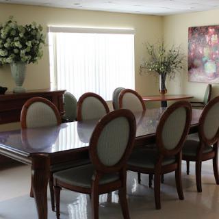 Elegant dining room with a large table, chairs, and floral decorations.