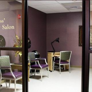 An interior view of a quiet nail salon with chairs and a desk.