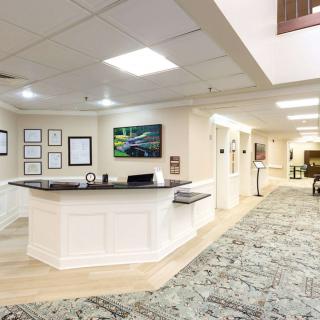 A modern reception area with a desk and a carpeted hallway.
