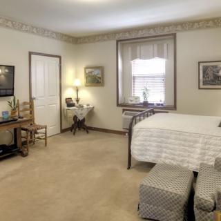 A cozy bedroom with neutral tones and classic furnishings.