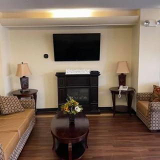 A cozy living room featuring a fireplace, sofas, and a mounted television.