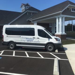 A white van parked outside a building, showcasing a clean and organized parking area.