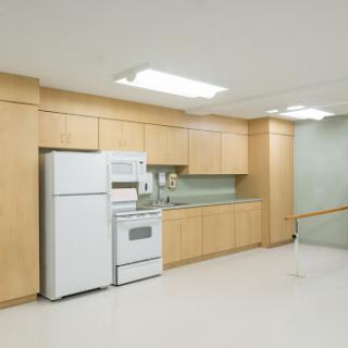 A modern kitchen featuring wooden cabinets and essential appliances.