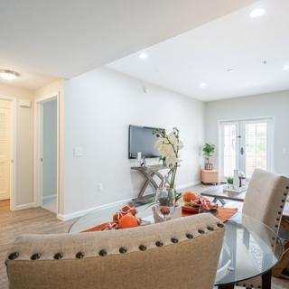 A modern living room with a comfortable sofa, sleek television setup, and large glass doors letting in natural light.