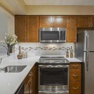 A modern kitchen with stainless steel appliances and wooden cabinets.