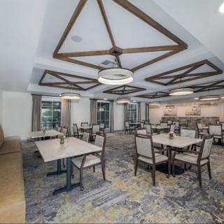 A modern dining room with elegantly designed furniture and decorative ceiling beams.