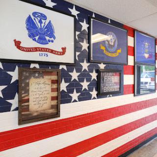 A vibrant wall display featuring American military symbols and a flag background.